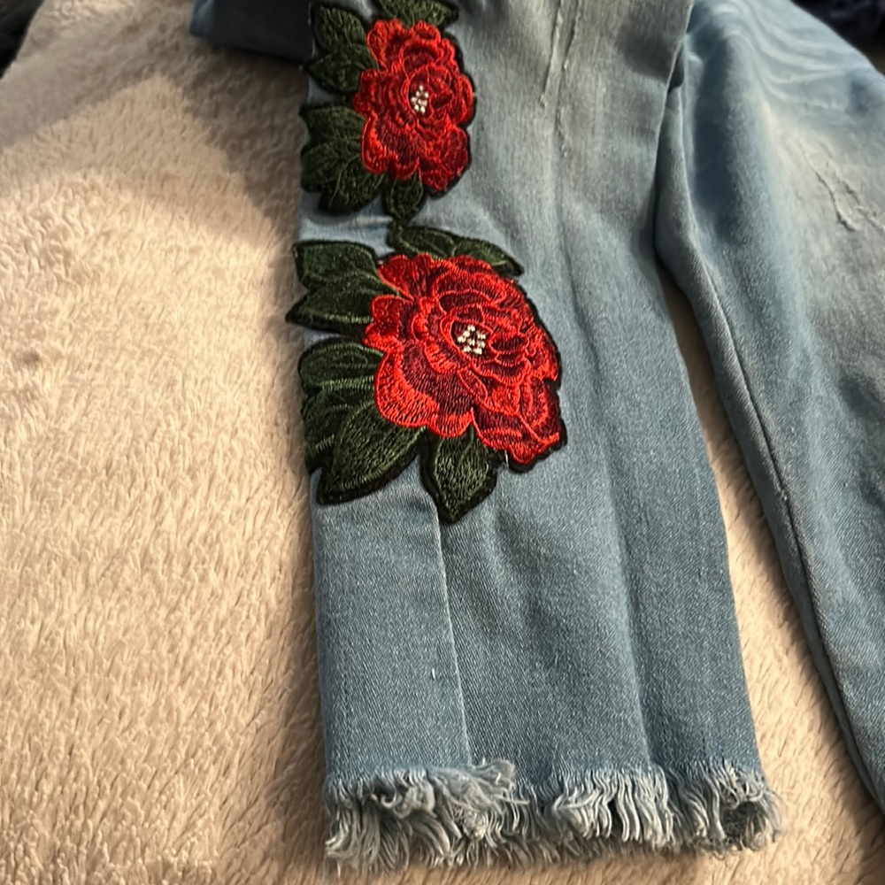 Girls jeans flower appliqué on both sides of the bottom of the jeans